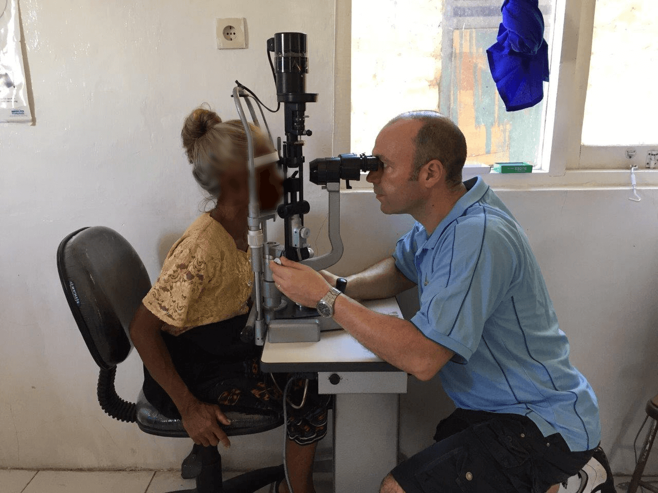 Optometrist conducting eye examination of patient